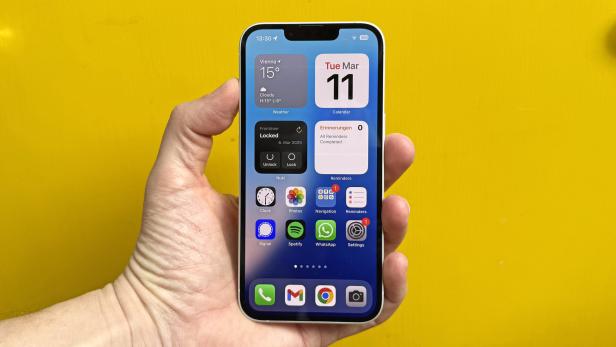Jemand hält ein iPhone in der Hand.