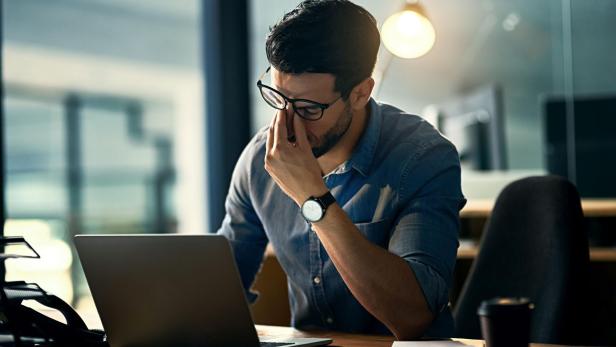 Burnout is killing his career Frustrierter Mann vorm Notebook