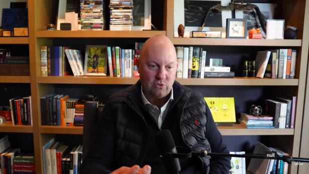 Investor Marc Andreessen hält seinen Job für unersetzlich. Screenshot des Videopodcasts: Marc Andreessen in einem Büro, vor ihm eine Mikrofon.