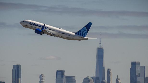 Vorerst ist Starlink-WLAN bei United Airlines nur auf der Strecke Chicago-Detroit verfügbar. ein United-Airlines Flugzeug im Steigflug vor einer Hochhaus-Skyline