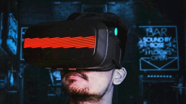 Ein Mann trägt ein Virtual-Reality-Brille in einem dunklen Raum.