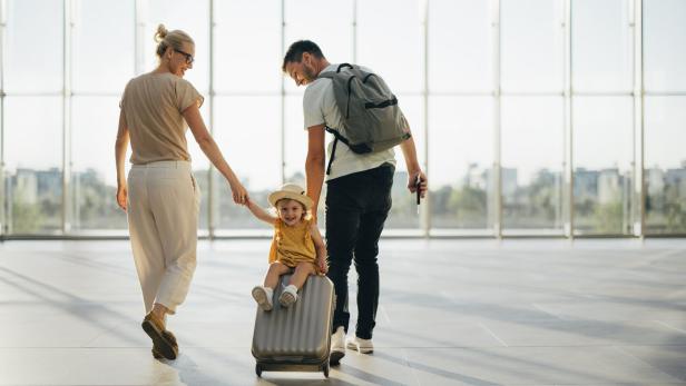 Young Family Having Fun Traveling Together Junge Familie mit Kind am Flughafen.