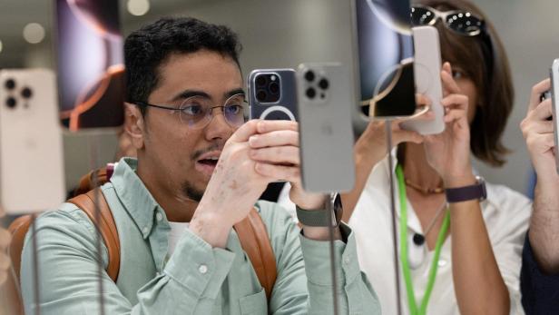 Ein Mann schaut auf ein iPhone (Symbolbild) Ein Mann schaut auf ein iPhone (Symbolbild)