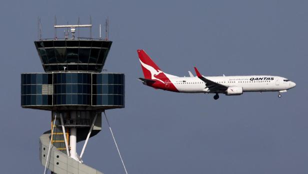 Ein Flugzeug fliegt am Tower des Flughafens von Sydney vorbei.