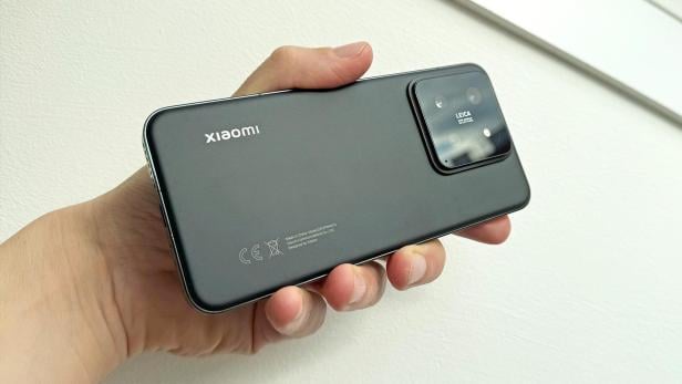 Ein schwarzes Xiaomi-Handy mit Leica-Kamera wird in der Hand gehalten.