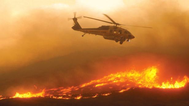 Ein Firehawk-Hubschrauber im Einsatz bei einem Waldbrand.