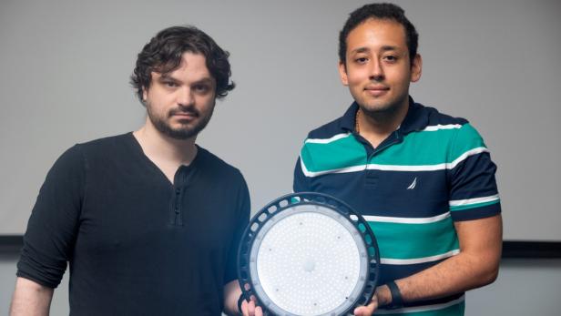 Abe Davis und Peter Michael von der Cornell University mit einer Wasserzeichen-Lampe.