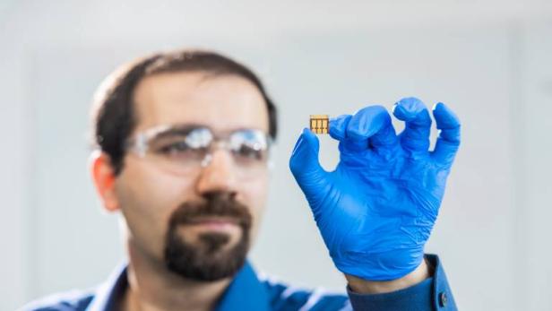 Ein Forscher mit einer kleinen Solarzelle.