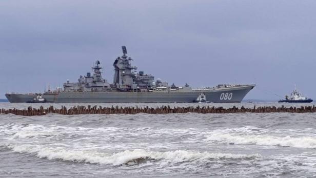 Der russische Kreuzer „Admiral Nachimow“ wird von Schleppern gezogen.