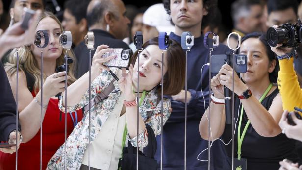 Besucher fotografieren die Apple Watch Serie 10 auf einem Launch-Event.