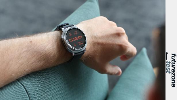 Eine Smartwatch am Handgelenk einer Person zeigt die Uhrzeit 13:35:01.