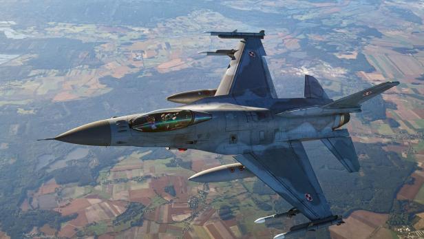 Ein polnisches Kampfflugzeug F-16 im Flug über Felder.