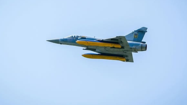 Ein Mirage 2000 Kampfflugzeug mit ukrainischer Flagge fliegt am Himmel.