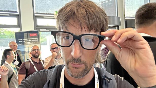 Ein Mann mit Brille der Marke Rokid auf einer Veranstaltung.