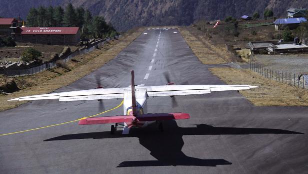 Ein Flugzeug startet auf der Landebahn des Flughafens Lukla.