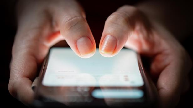 Eine Person tippt auf dem Bildschirm eines Smartphones.