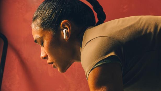 Eine verschwitzte Frau mit einem Zopf trägt Apple AirPods Pro.