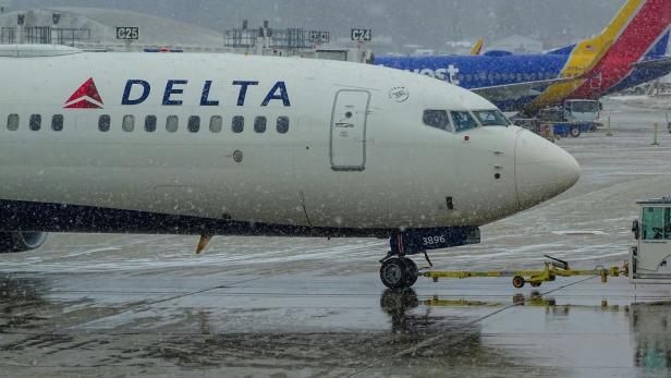 Ein Symbolbild für ein Flugzeug von Delta, das am Flughafen im Regen steht.