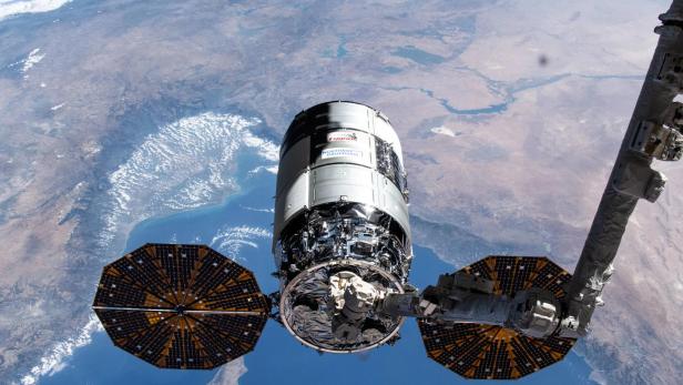 Das 21. Cygnus-Frachtschiff von Northrop Grumman, das 2024 bei der ISS angedockt ist. Zu sehen sind die Solar-Panels sowie der Greifarm.