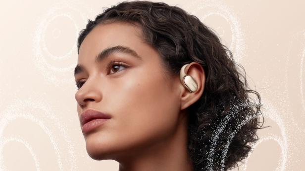 Eine Frau trägt goldfarbene Xiaomi Open Wear Stereo Pro Ohrhörer.