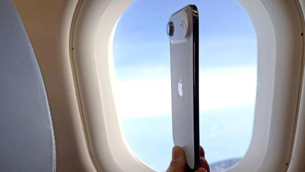 iPhone Air vor einem Flugzeugfenster