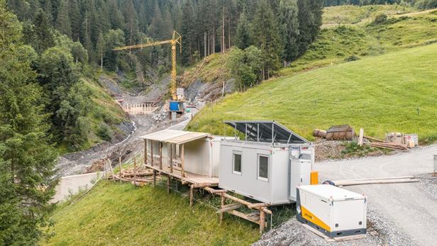 Ein Liebherr-Akku mit 94 kWh Kapazität versorgt eine Baustelle im Salzburger Gebirge, um Schutzmaßnahmen gegen Steinschlag zu ermöglichen.