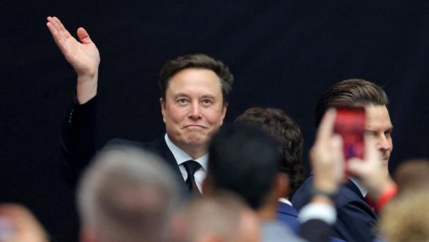 Elon Musk winkt einer Menschenmenge zu.