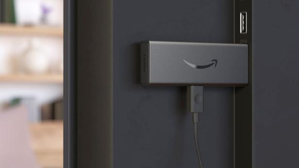 Ein älteres Modell des Fire TV Stick steckt an einem TV-Gerät
