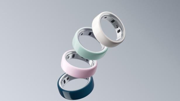 die vier bunten Oura Ringe schweben vor grauem Hintergrund