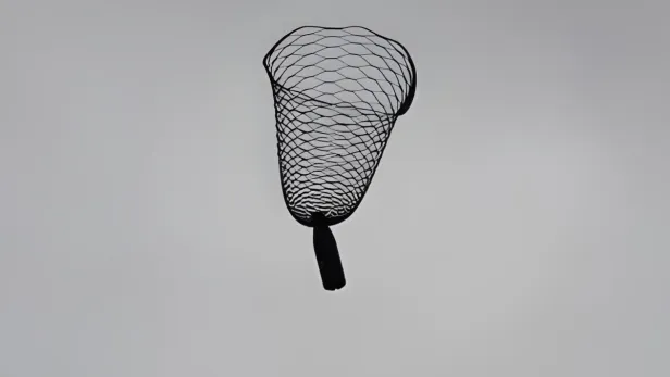 Ein Fallschirm voller Löcher mit einer Flasche am unteren Ende.