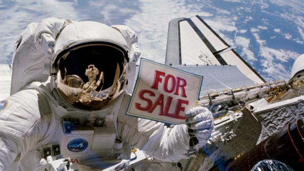 Ein NASA-Astronaut hält ein "For Sale"-Schild. (Symbolbild)