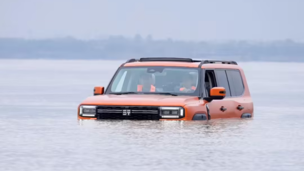Der orange Jetour Zongheng G700 von Chery schwimmt mit nur sichtbarer Fahrzeugoberseite durch den Jangtse-Fluss.
