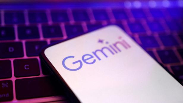 Ein Smartphone mit dem Gemini-Logo liegt auf einer Laptop-Tastatur.