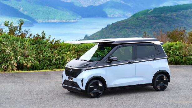 Nissan Sakura mit Solardach vor einem See mit Bergen