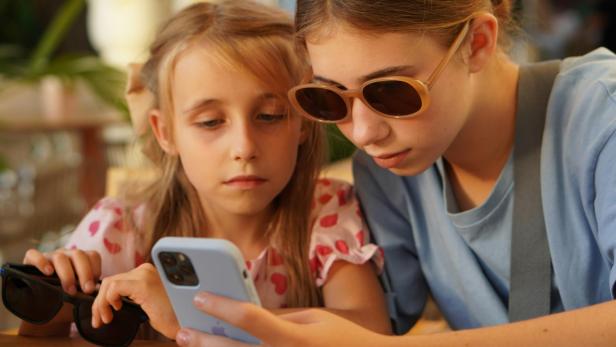 2 Mädchen schauen auf Smartphone