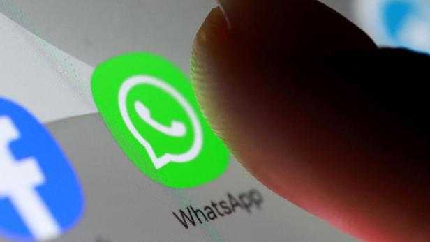 Ein Finger tippt auf das grüne WhatsApp-Symbol auf einem Smartphone-Bildschirm.