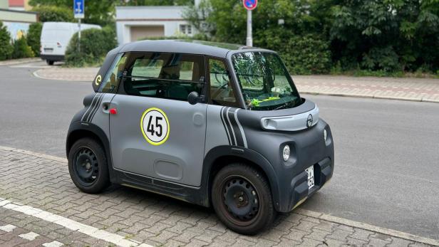 Ein Microcar steht am Straßenrand, wie sie künftig mit nachhaltigen Natrium-Ionen-Batterien aus Holz betrieben werden könnten.