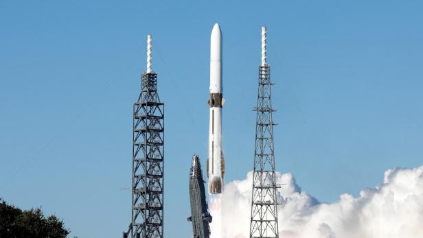 Eine Rakete startet zwischen zwei Starttürmen mit Rauch und Flammen in den Himmel.