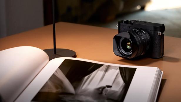Leica Q3 Monochrom auf einem Tisch mit Fotobuch
