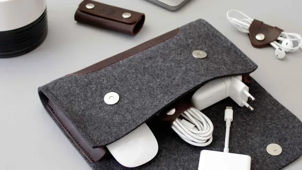 Pack and Smooch - Tasche das Organisieren von Kabeln liegt mit Steckern und Handykabeln offen am Tisch