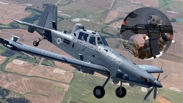 Ein graues Militärflugzeug der US-Luftwaffe fliegt über Felder, im Kreis ist ein Soldat mit einem Sturmgewehr zu sehen.