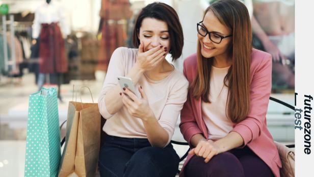 2 Frauen schauen auf das Smartphone und lachen 
