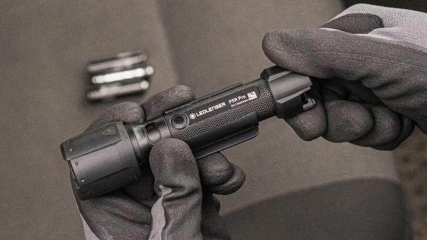 Eine Person mit Handschuhen hält die Taschenlampe P5R Pro von Ledlenser in den Händen.