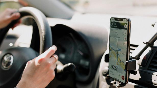 Lenkrad und Smartphone mit Google Maps 