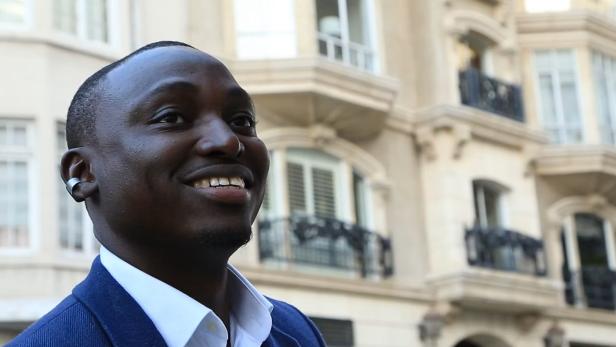 Mann mit smartem Ohrring-Wearable vor einem Gebäude in der Stadt.