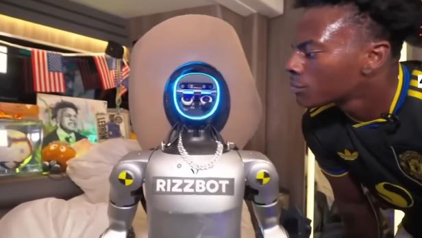 IShowSpeed steht vor einem silbernen "Rizzbot"-Roboter mit leuchtenden Augen.