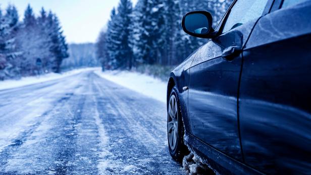 Ein Auto fährt über eine vereiste Straße 