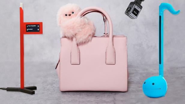 Mini Haltenstellenanzeiger auf grauem Hintergrund neben einer pinken Handtasche