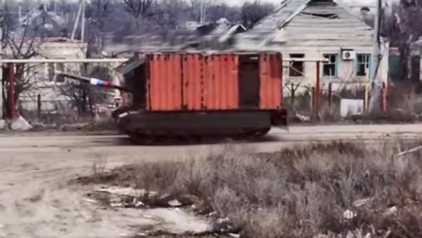 Russischer Container-Panzer fährt auf einer staubigen Straße