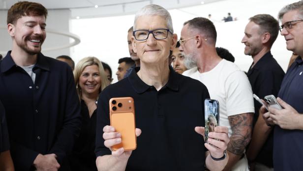 Apple-Chef Tim Cook hält 2 iPhones in der Hand